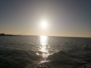 sun in sky glistering on the sea loch 